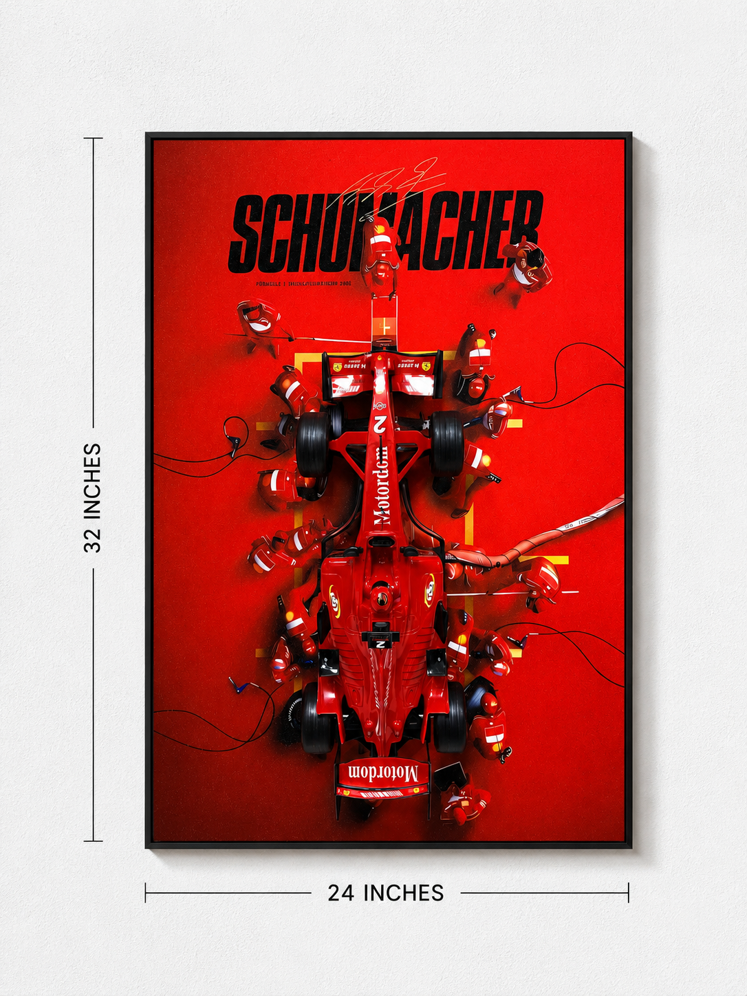 A framed vertical poster featuring a red Formula 1 race car with pit crew members and the word 'SCHUMACHER' in large black letters on a bright red background. White dimension lines indicate 32 inches tall by 24 inches wide, shown against a light gray wall.