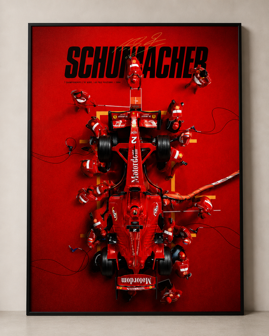 A framed red Formula 1 wall art print featuring a stylized pit-stop scene with red cars and crew, large black 'SCHUMACHER' text at the top, and a black frame against a light neutral wall.